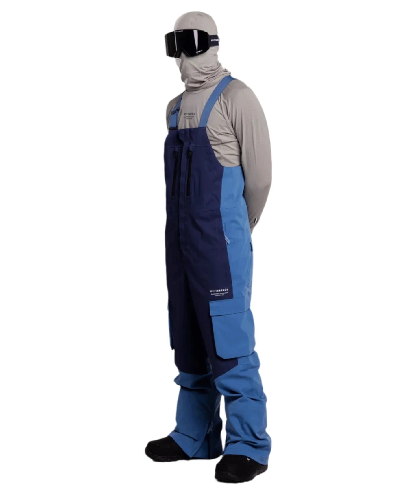 Whitespace 2L Cargo Insulated Bib Pants 2024 - A pair of dark blue snow pants with cargo pockets on each thigh and a black zipper at the ankle.