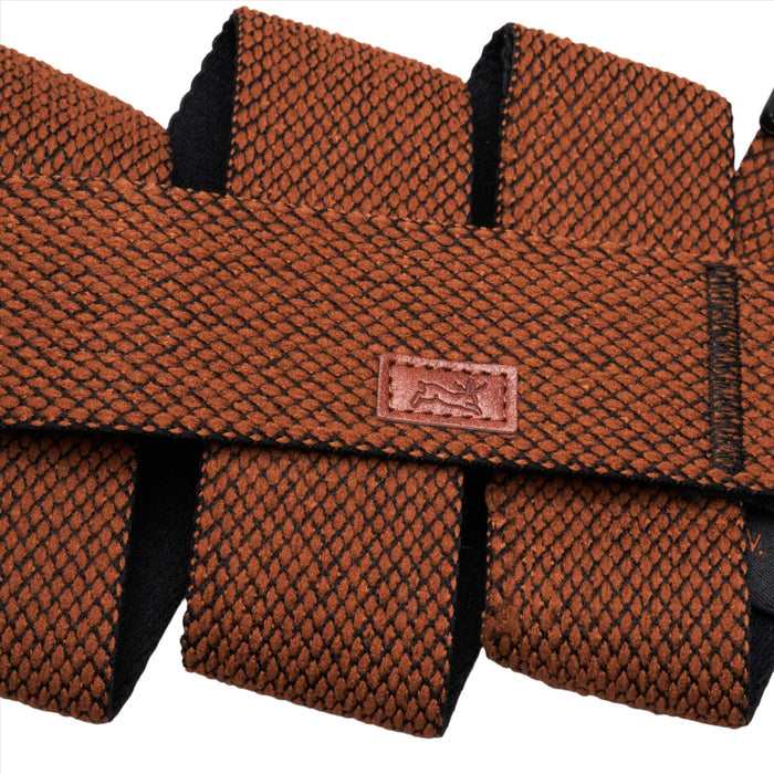 Close-up of the orange belt showing the detailed textured pattern, along with the small leather patch with a jackalope logo.