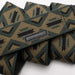 Close-up of the dark green belt showing the detailed pattern of tan triangles with black claw marks, along with the black leather patch that reads "ARCADE."