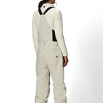 Women’s insulated off-white bib overalls, back view with full suspenders and pocket details.