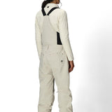 Women’s insulated off-white bib overalls, back view with full suspenders and pocket details.