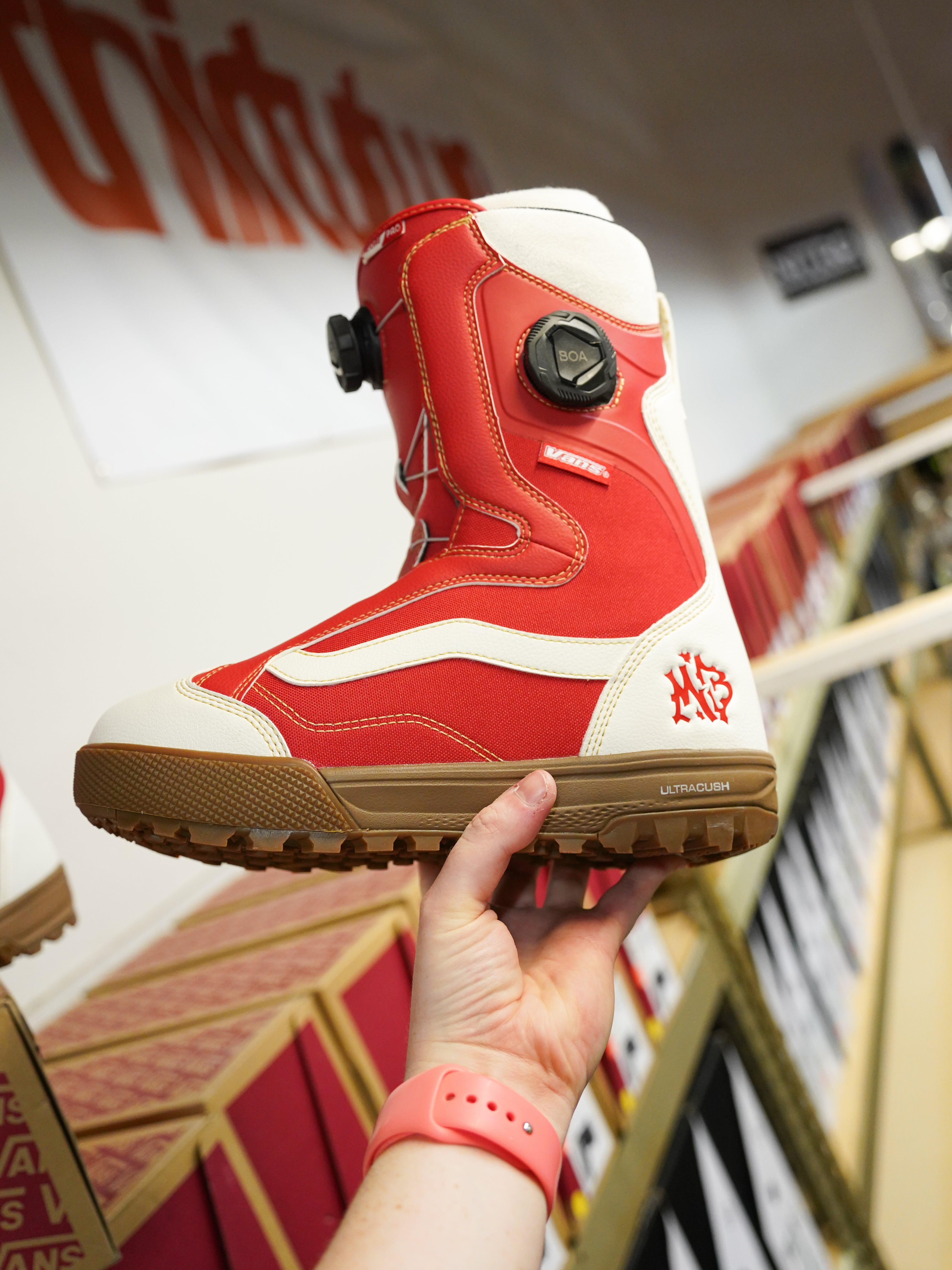 Vans Women's Encore Pro Limited Edition Snowboard Boots 2026 - A pair of red snowboard boots with white accents and a black BOA dial on the side.