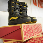 Vans Invado Pro Limited Edition Snowboard Boots 2026 - Black boots with yellow accents and stitching, featuring a distinctive wavy logo on the side.