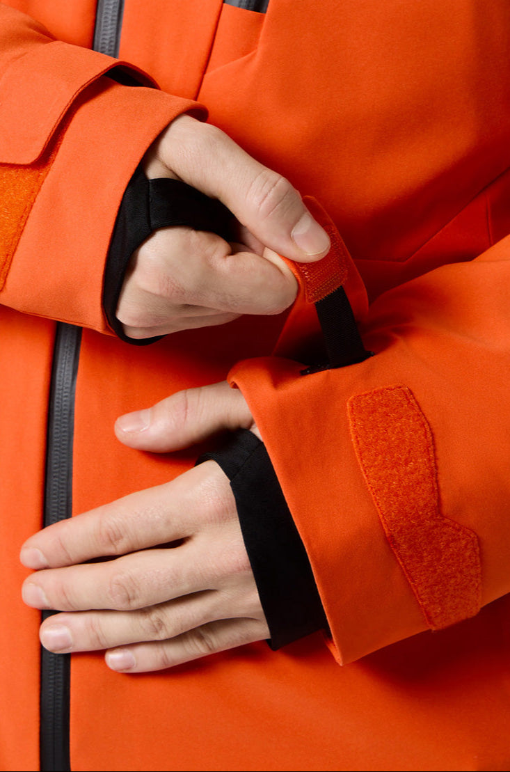 Descente Cody Insulated Jacket 2025 - A bright orange jacket with a black zipper and two zippered pockets on either side.