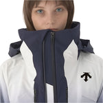Descente Women's Swiss Insulated Jacket 2025 - A navy blue and white insulated jacket with a zippered front, worn by a woman with short brown hair.