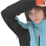 Descente Women's Lisa Insulated Jacket 2025 - A woman wearing a black and light blue jacket with an orange zipper, looking at the camera from above.
