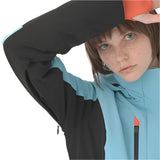 Descente Women's Lisa Insulated Jacket 2025 - A woman wearing a black and light blue jacket with an orange zipper, looking at the camera from above.