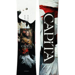 CAPiTA Women's Birds of a Feather Snowboard 2025 - A black snowboard with white feathers and red accents, featuring a woman's face in the center.