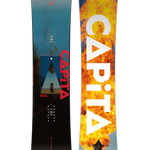CAPiTA Defenders Of Awesome Snowboard 2025 - A blue and black snowboard with a triangular logo featuring a person standing in front of a mountain range, set against a dark background.