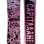 CAPiTA - Junior's Scott Stevens Mini Snowboard 2025 is a pink snowboard with black graphics of various shapes and sizes, including a cartoonish face, a mountain range, and a pair of skis.