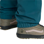 Airblaster Elastic Boss Shell Pant 2025 - A pair of dark green snow pants with a zippered pocket on the side and elastic cuffs at the ankles.