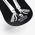 Endeavor Skull Skates Snowboard 2025 - A black snowboard with a white skull graphic on top of a mountainous landscape.
