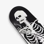 Endeavor Skull Skates Snowboard 2025 - A black snowboard with a white skull graphic on top of a gray background.