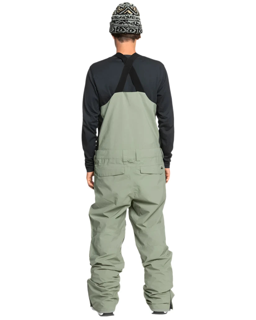 Quiksilver Utility Shell Bib - A pair of olive green snow pants with a black zipper and two zippered pockets on the side.