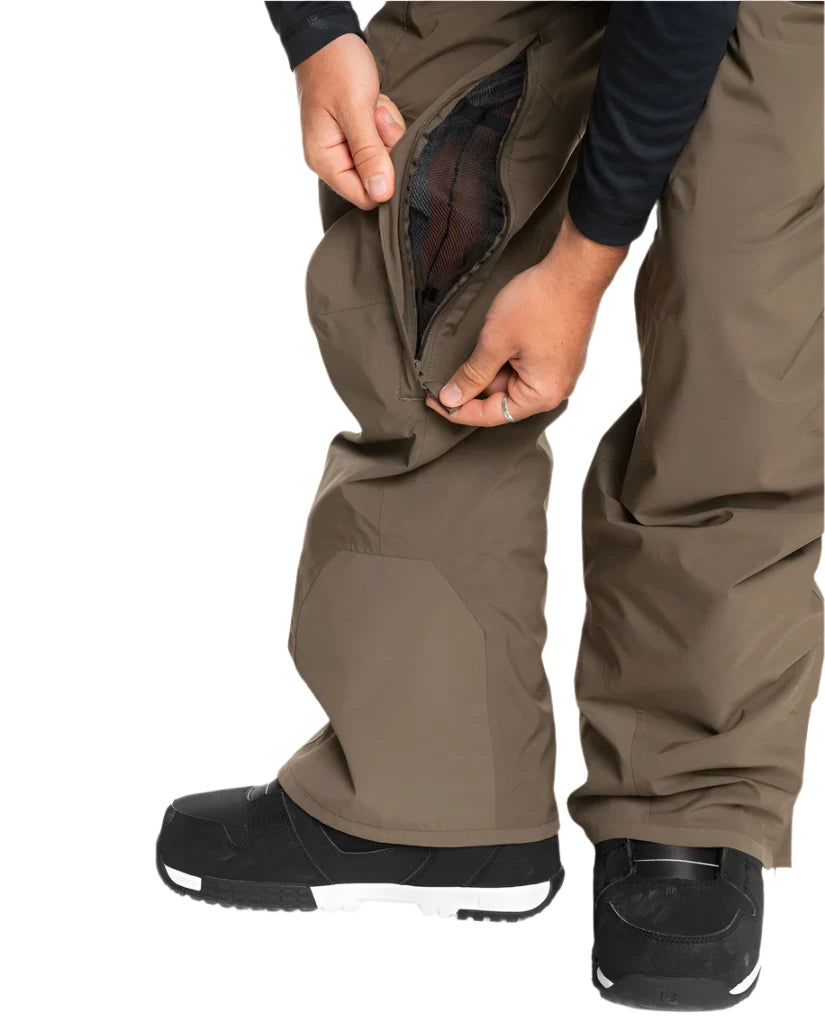Quiksilver Utility Shell Pant 2025 - A pair of khaki-colored snow pants with a zippered pocket on the thigh and a black logo patch on the left leg.
