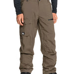 Quiksilver Utility Shell Pant 2025 - A pair of khaki-colored snow pants with a black logo patch on the left thigh and two zippered pockets on the right leg.