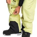 Quiksilver Utility Shell Pant 2025 - A pair of khaki-colored snow pants with a zippered pocket on the thigh and black accents around the ankles.