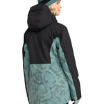Roxy Women's Stated Insulated Jacket 2025 - A black and teal floral patterned jacket with a hood, worn by a model facing left.