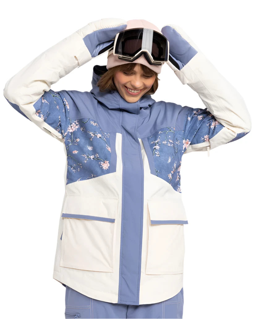 Roxy Women's Chloe Kim Parka Jacket 2025 - A blue and white parka jacket with a floral pattern on the chest, worn by a model posing in front of a plain background.