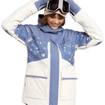 Roxy Women's Chloe Kim Parka Jacket 2025 - A blue and white parka jacket with a floral pattern on the chest, worn by a model posing in front of a plain background.