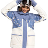 Roxy Women's Chloe Kim Parka Jacket 2025 - A blue and white parka jacket with a floral pattern on the chest, worn by a model posing in front of a plain background.
