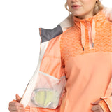 Roxy Women's Meade Insulated Jacket - A peach-colored jacket with a geometric pattern on the upper portion, featuring a zippered chest pocket and a drawstring at the waist.