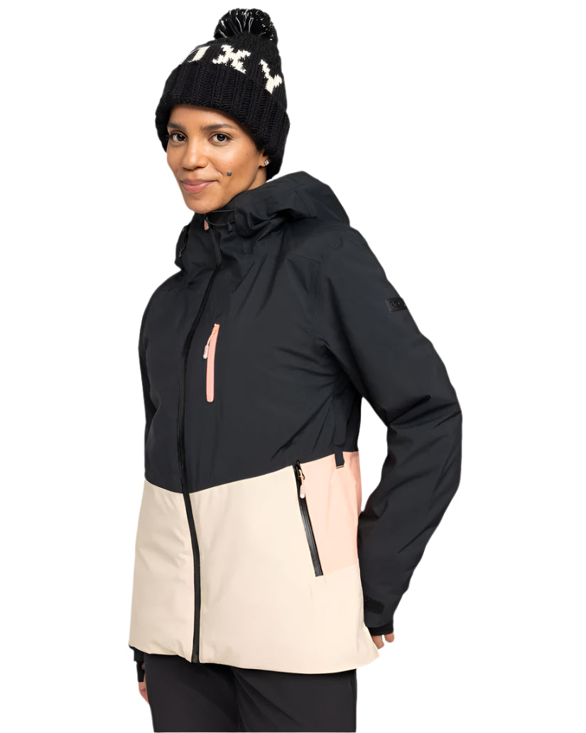 Roxy Women's Peakside Insulated Jacket 2025 - A black and white snowflake patterned beanie is worn atop a woman wearing an insulated jacket with a black upper section, cream-colored lower section, and pink zipper.