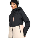 Roxy Women's Peakside Insulated Jacket 2025 - A black and white snowflake patterned beanie is worn atop a woman wearing an insulated jacket with a black upper section, cream-colored lower section, and pink zipper.