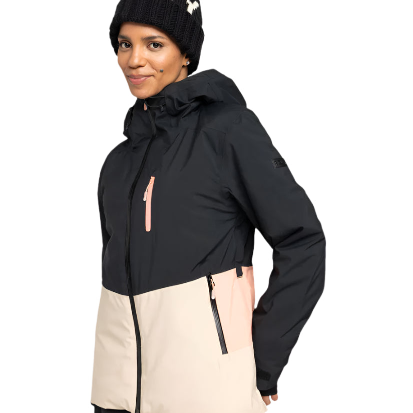 Roxy Women's Peakside Insulated Jacket 2025 - A black and white snowflake patterned beanie is worn atop a woman wearing an insulated jacket with a black upper section, cream-colored lower section, and pink zipper.