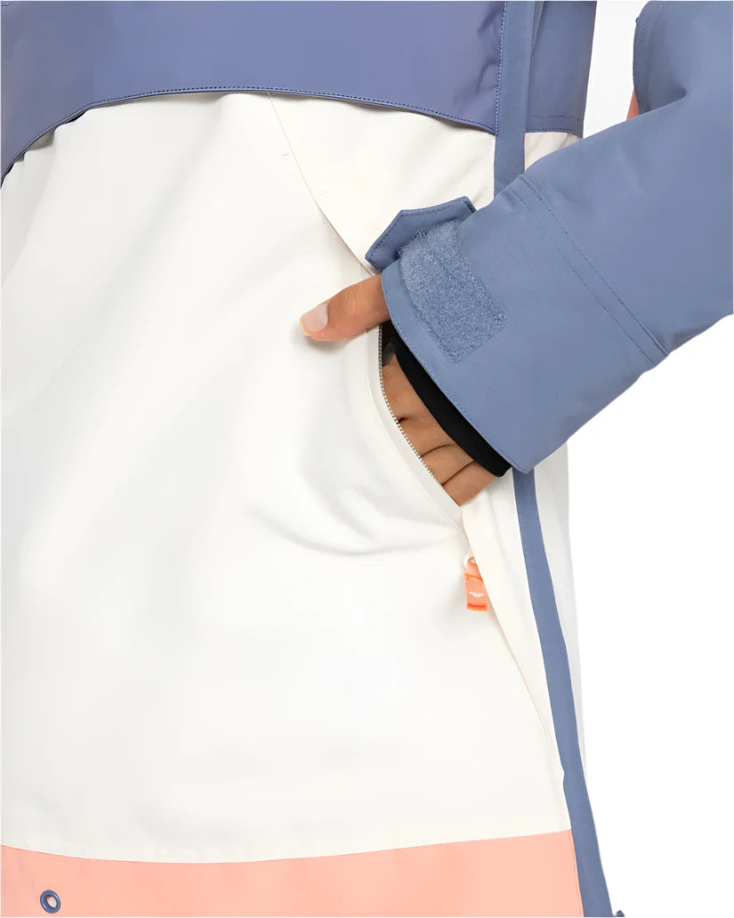 Roxy Women's Shelter Insulated Jacket 2025 - A woman's hand is reaching into a zippered pocket on the side of this jacket, which has a white body with a pink stripe at the bottom and blue trim.