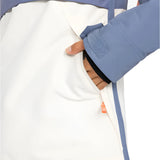 Roxy Women's Shelter Insulated Jacket 2025 - A woman's hand is reaching into a zippered pocket on the side of this jacket, which has a white body with a pink stripe at the bottom and blue trim.