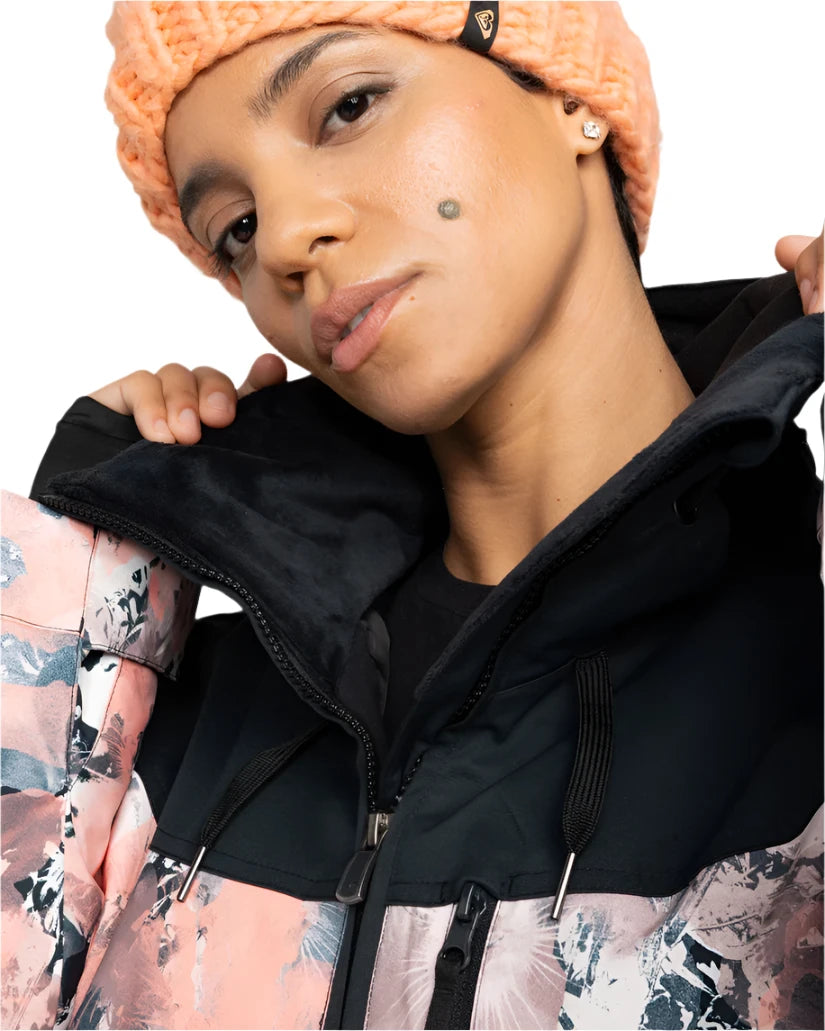 Roxy Women's Presence Insulated Parks Jacket 2025 - A light blue jacket with a white snowflake pattern and black accents, worn by a model posing in front of a snowy mountain backdrop.