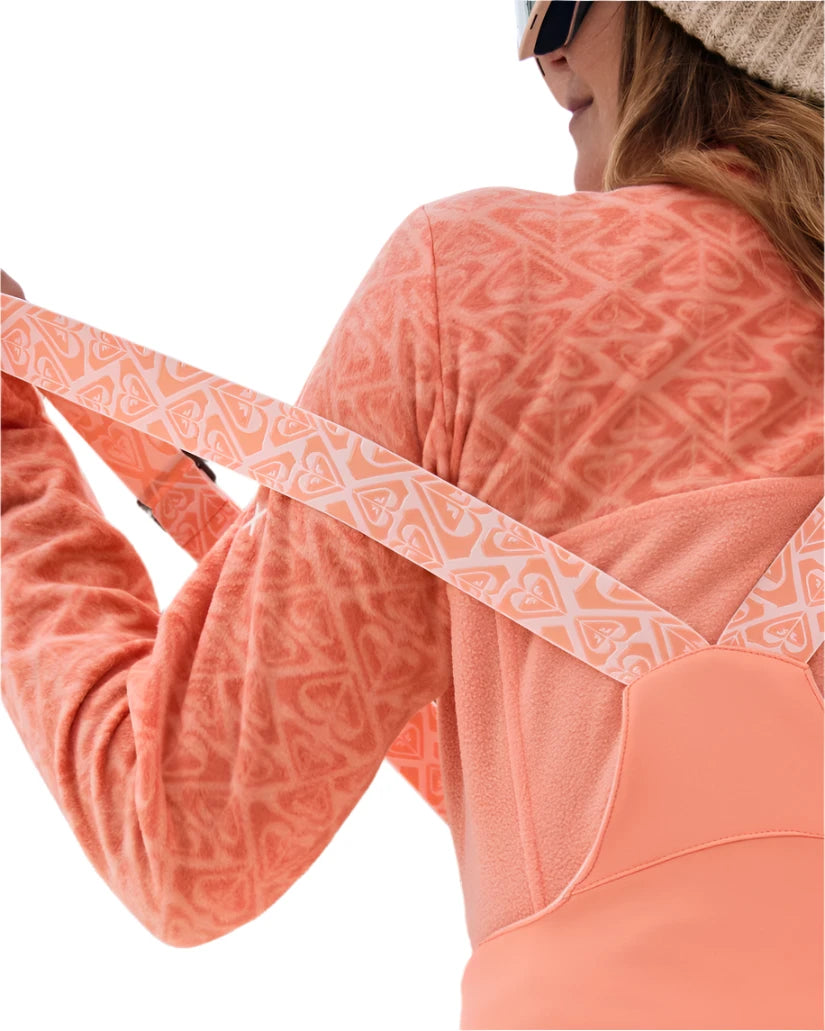 Roxy Women's Summit Bib Shell Pant 2025 - A coral-colored snow bib shell pant with a repeating pattern of hearts and triangles, featuring a zippered pocket on the side.