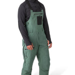 Flylow Baker Bib 2025 - Dark green bib with black straps, zippered leg pockets, and a flylow logo on the left thigh.