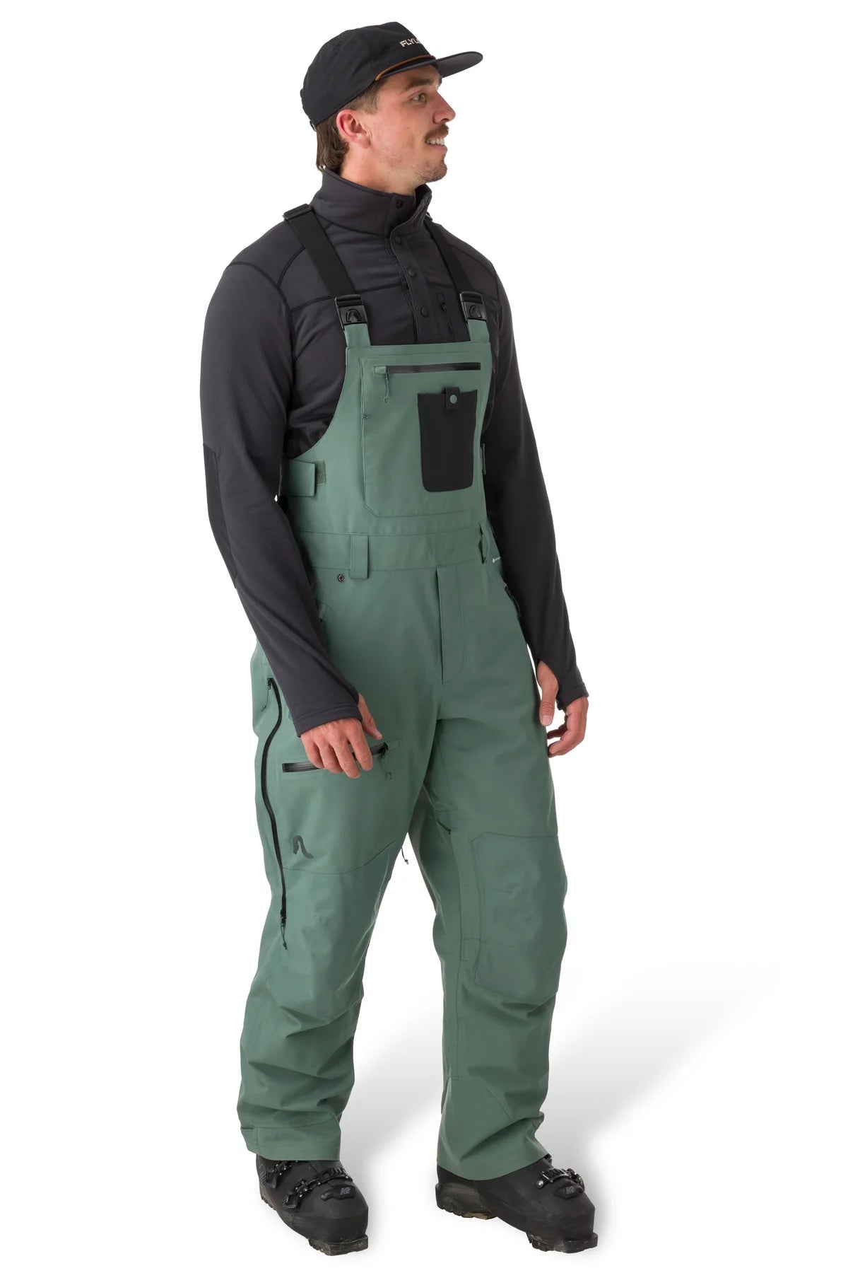Flylow Baker Bib 2025 - Dark green bib with black straps, zippered leg pockets, and a flylow logo on the left thigh.