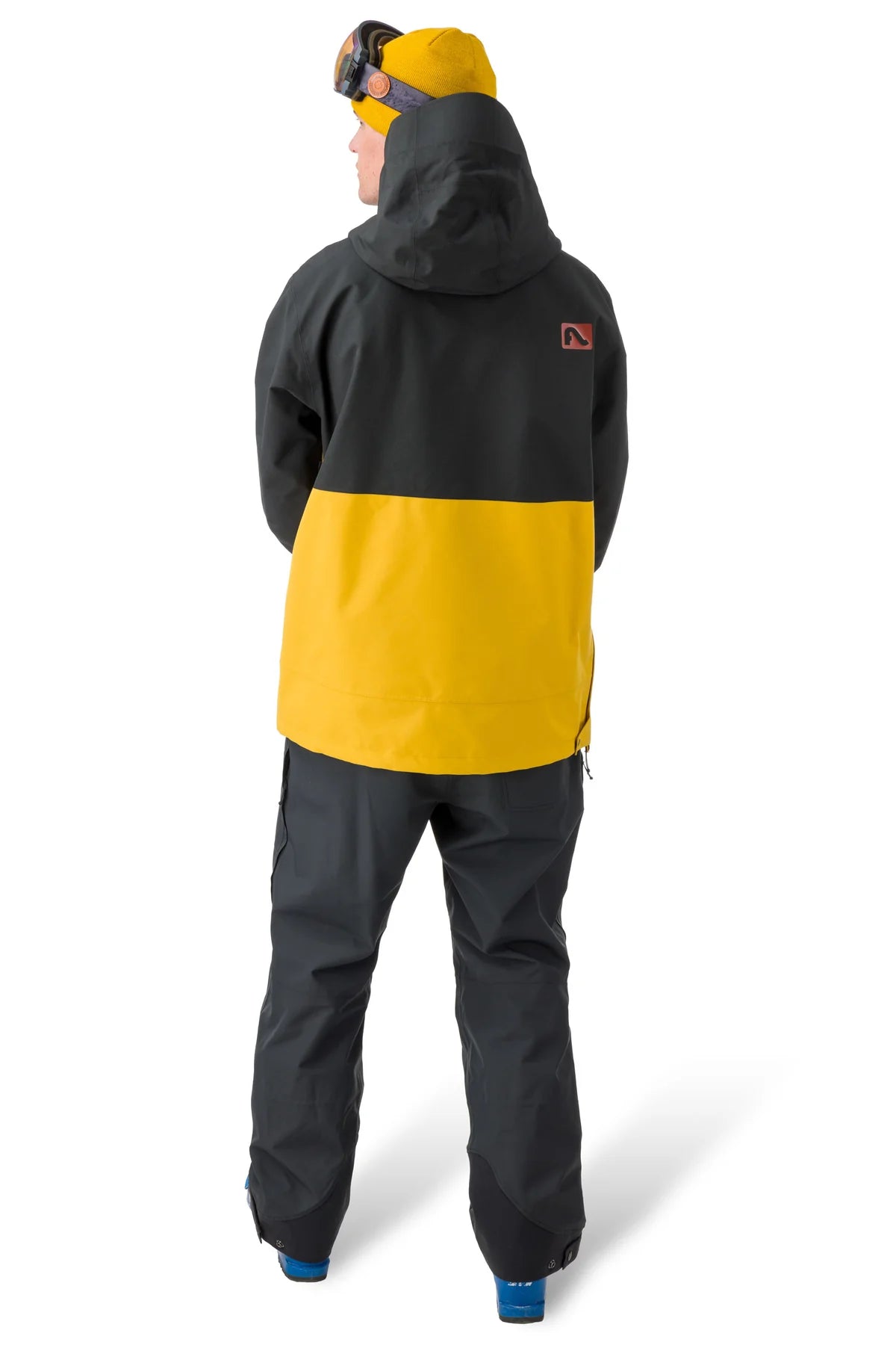 Flylow Knight Anorak Jacket - A black jacket with a yellow stripe across the chest and down the back, featuring a hood and zippered pockets.