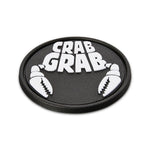 Crab Grab The Logo Stomp Pad 2025 - A black oval-shaped pad with a raised white logo featuring the words "CRAB GRAB" in bold block letters, flanked by two crab claws on either side.