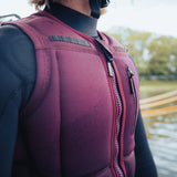 Follow Capiva Impact Vest 2024 - A red impact vest with a black logo on the upper left side and a black strap at the back.