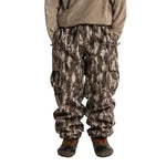Camouflage cargo shell pants worn, with an elastic waist and flap thigh pockets