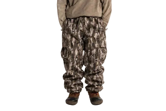 Camouflage cargo shell pants worn, with an elastic waist and flap thigh pockets