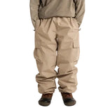 Stone cargo shell pants worn, with an elastic waist and flap thigh pockets