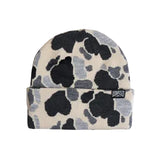 Knit beanie in a black, gray, and cream camouflage pattern with a folded cuff and logo patch