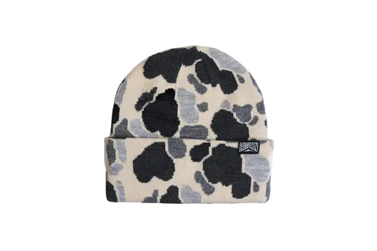 Knit beanie in a black, gray, and cream camouflage pattern with a folded cuff and logo patch