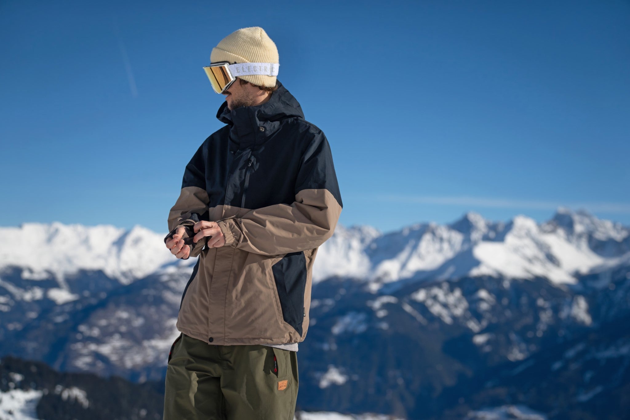 Volcom 2L Insulated GORE-TEX Jacket - A tan and black jacket with a hood, featuring two zippered pockets on the front.