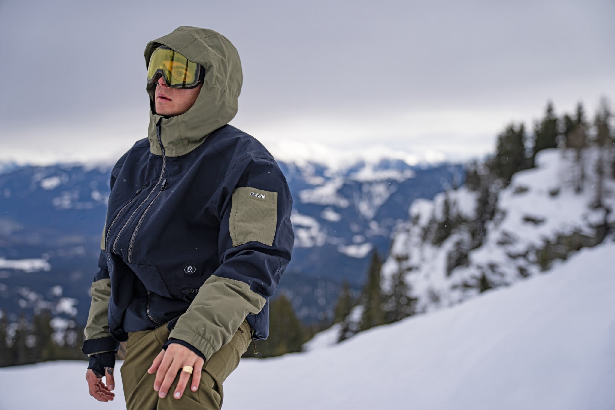 Volcom V.co Wfo Shell Jacket 2025 - A navy blue jacket with olive green accents and a hood, featuring a zipper closure.