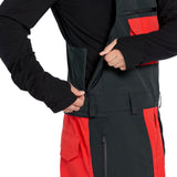 Volcom Men's Rain GORE-TEX Bib Overall - A black bib overall with a red stripe down the side and a zipper on the front.