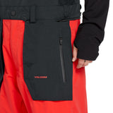 Volcom Men's Rain GORE-TEX Bib Overall - A black bib overall with a red stripe down the side and a zipper on the left leg.