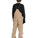 Volcom Men's Rain GORE-TEX Bib Overall - A pair of khaki-colored bib overalls with a black strap and buckle at the back, featuring two front pockets and a zippered pocket on the thigh.
