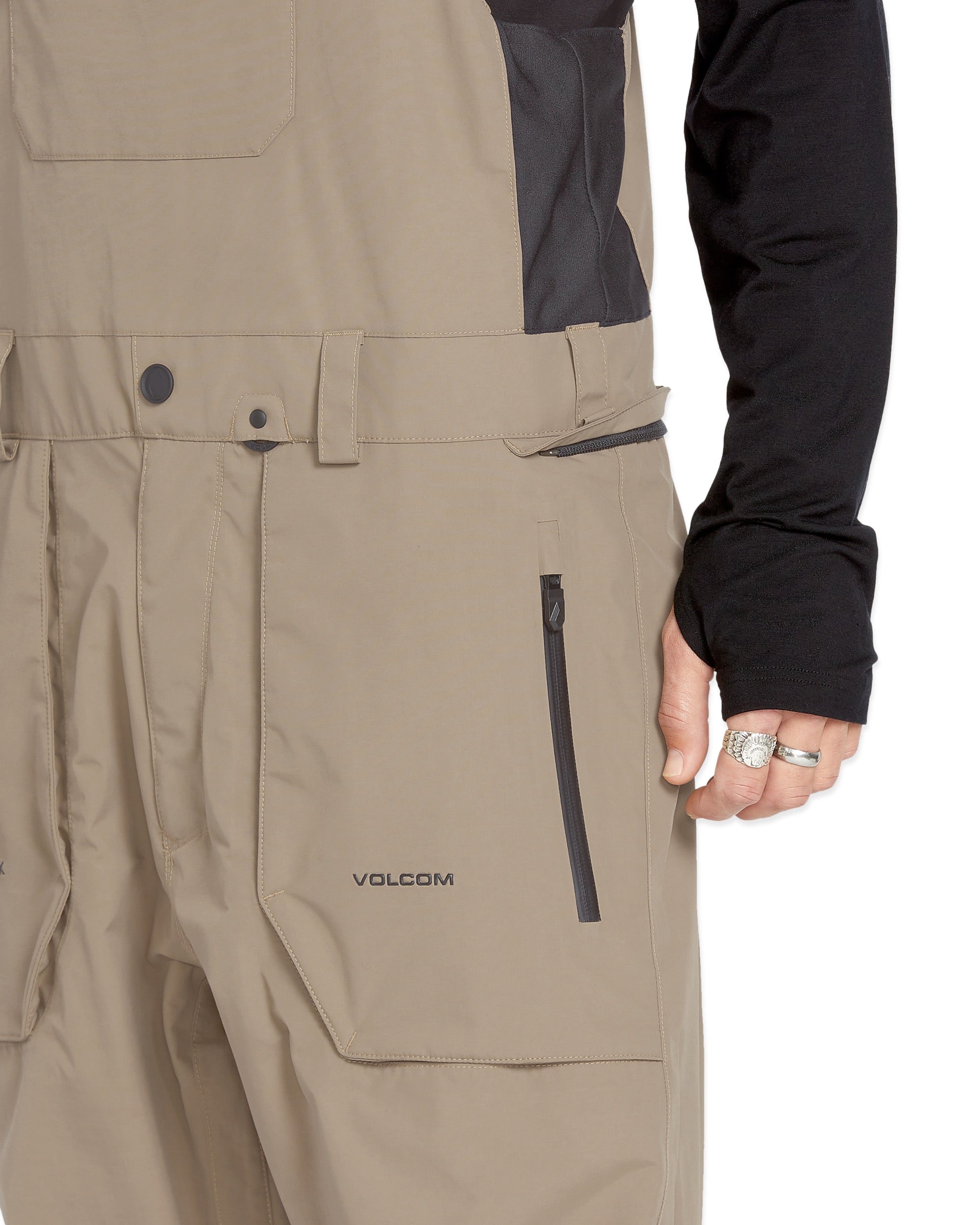 Volcom Men's Rain GORE-TEX Bib Overall - A pair of khaki-colored rain bib overalls with a black zipper and belt loops.