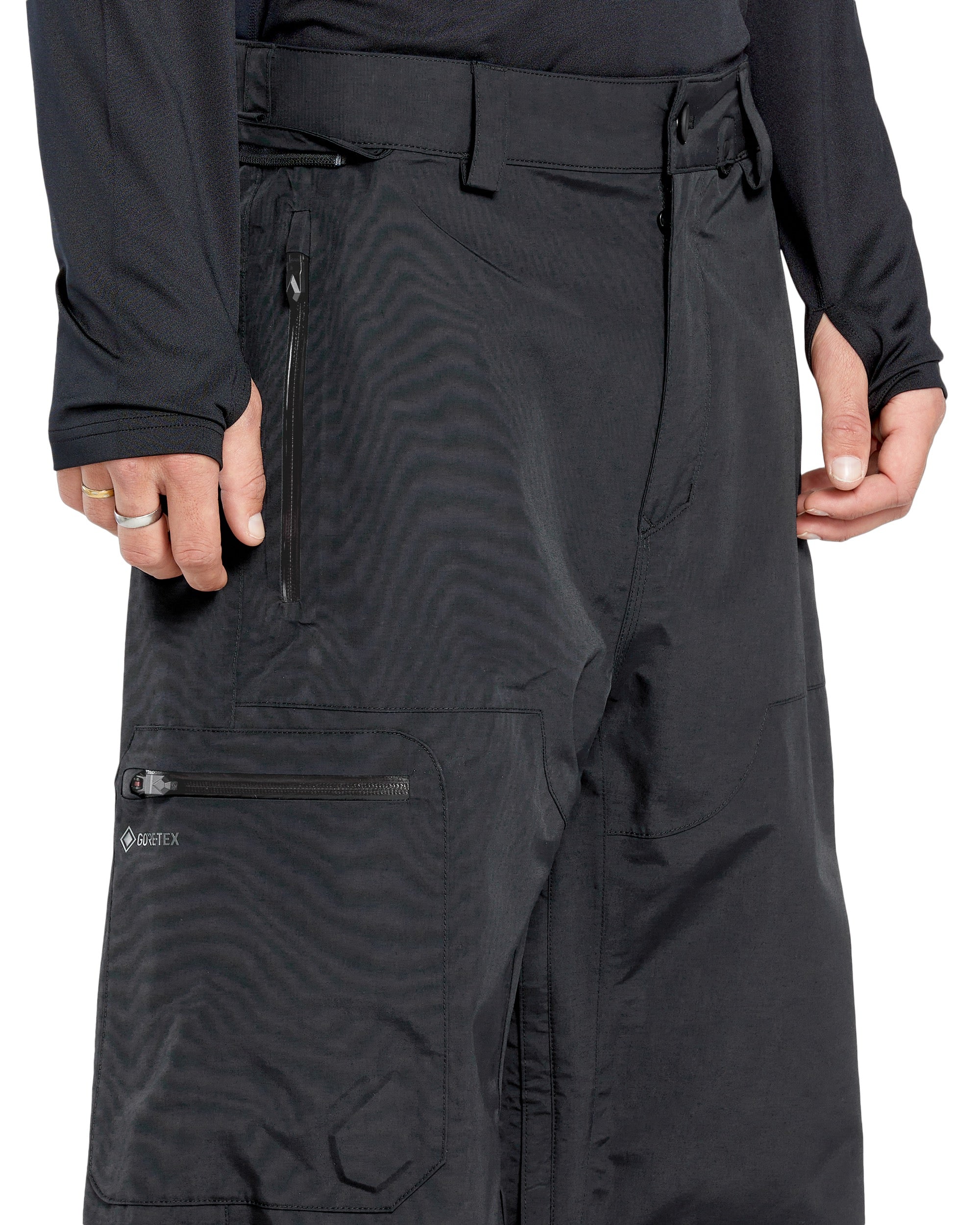 Volcom Men's L GORE-TEX Shell Pant - Black pants with a zippered pocket on the thigh and a logo patch on the left leg.